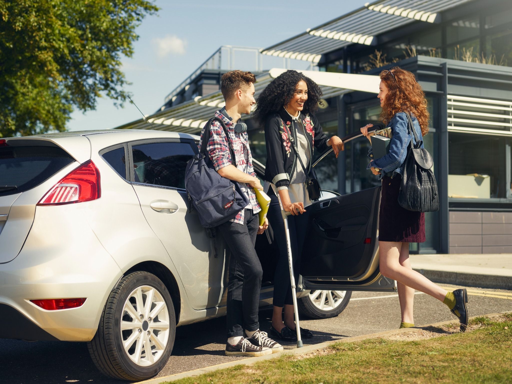 Friends gathered around a Motability vehicle