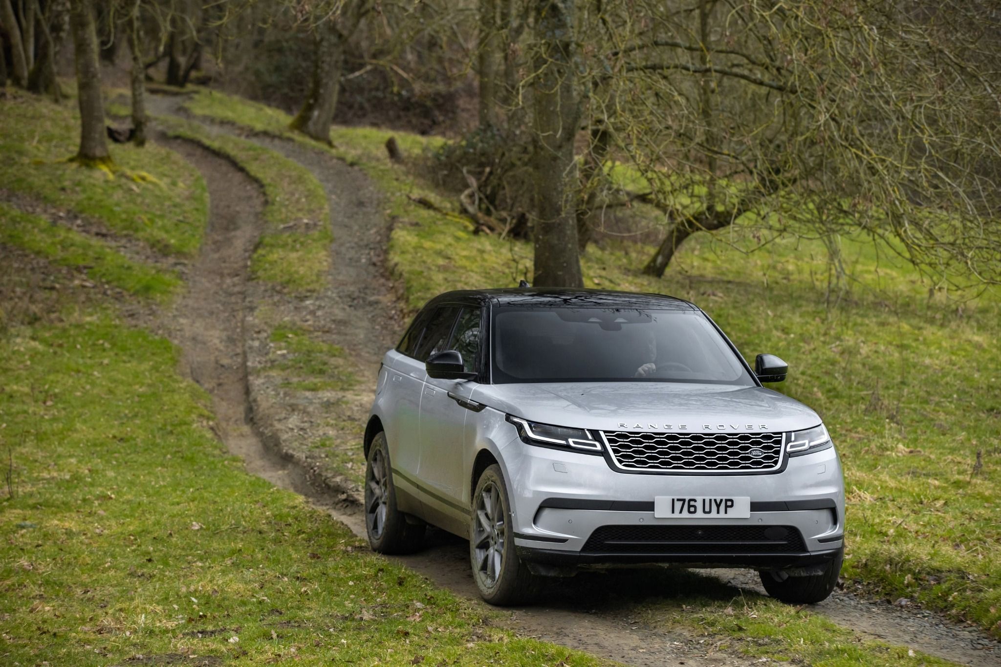 Silver Range Rover Velar driving down a dirt road