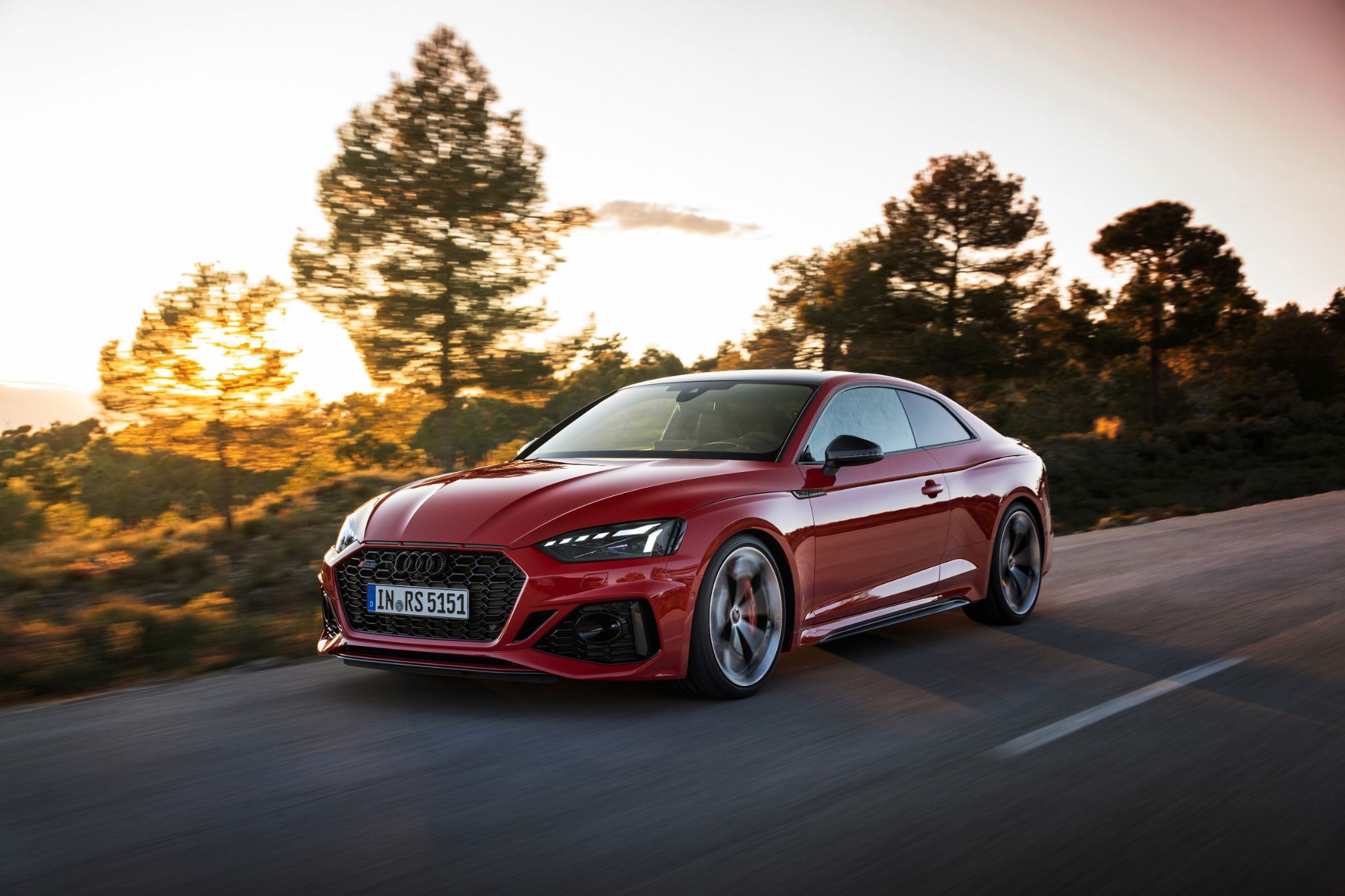 Red Audi RS5 Coupe driving on a road