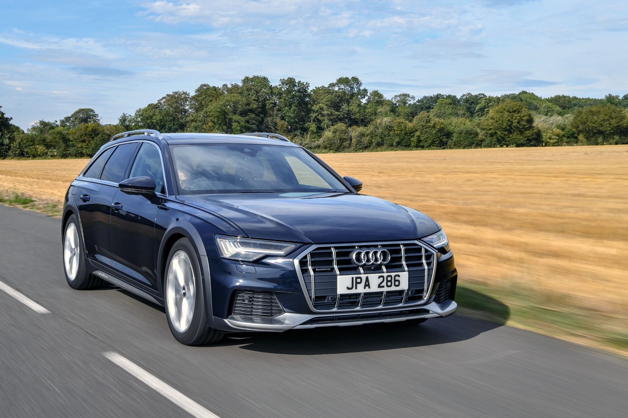 Front view of an Audi A6 allroad driving on a road