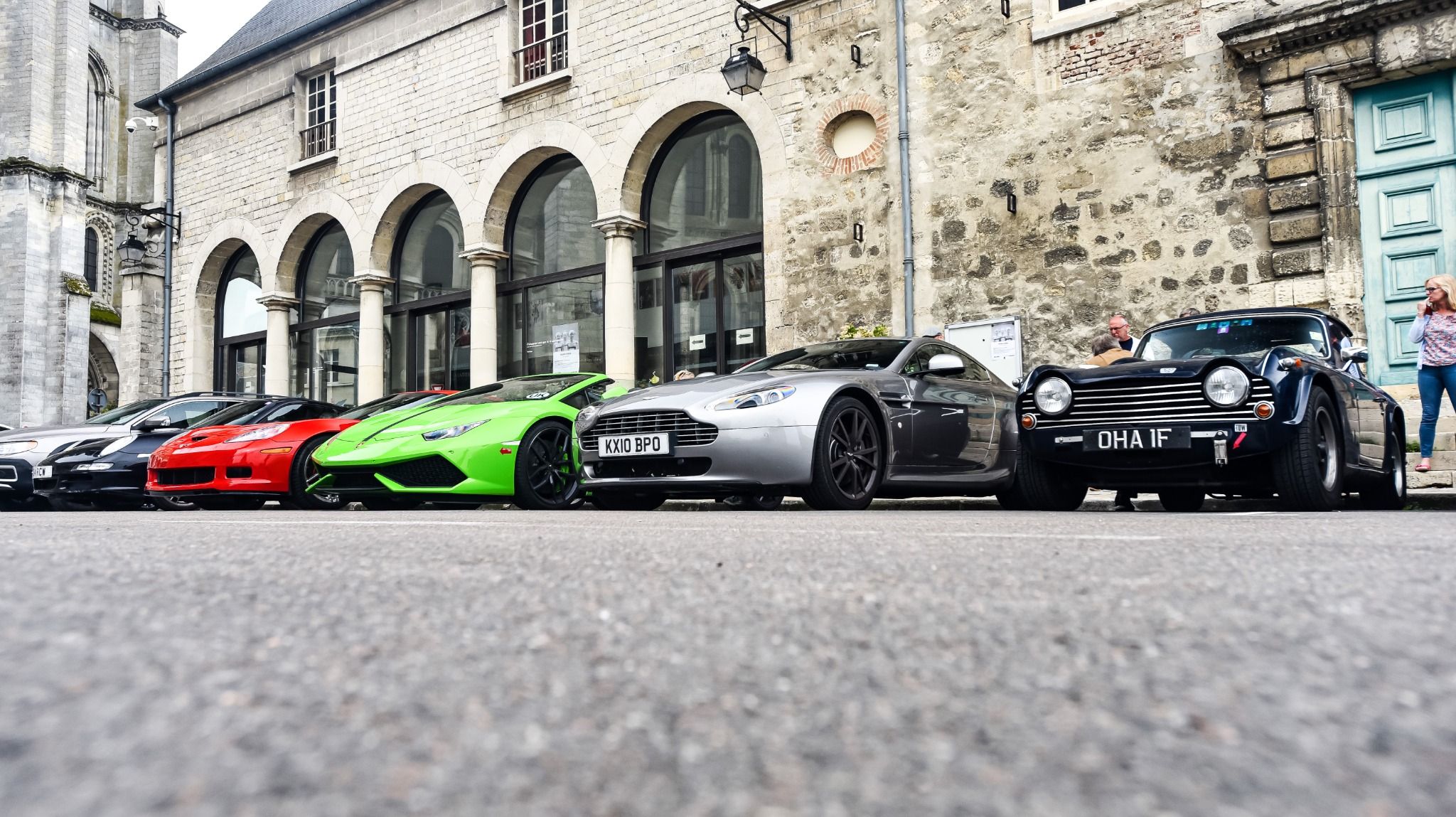 Six sport cars parked in a row next to a building