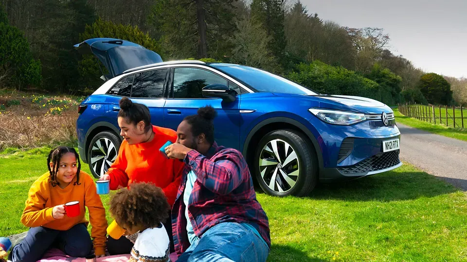 Family having a picnic next to A Purple Volkswagen ID.4