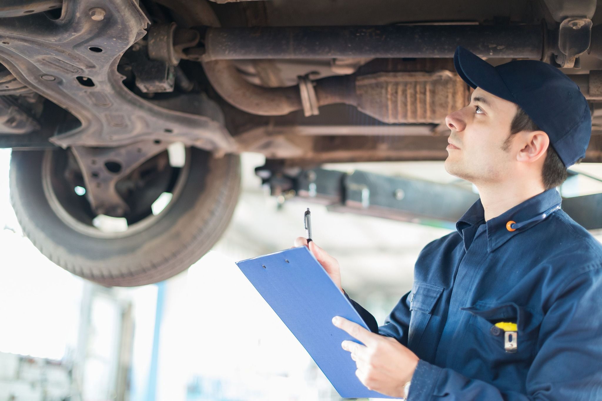 Technician checking underneath a car