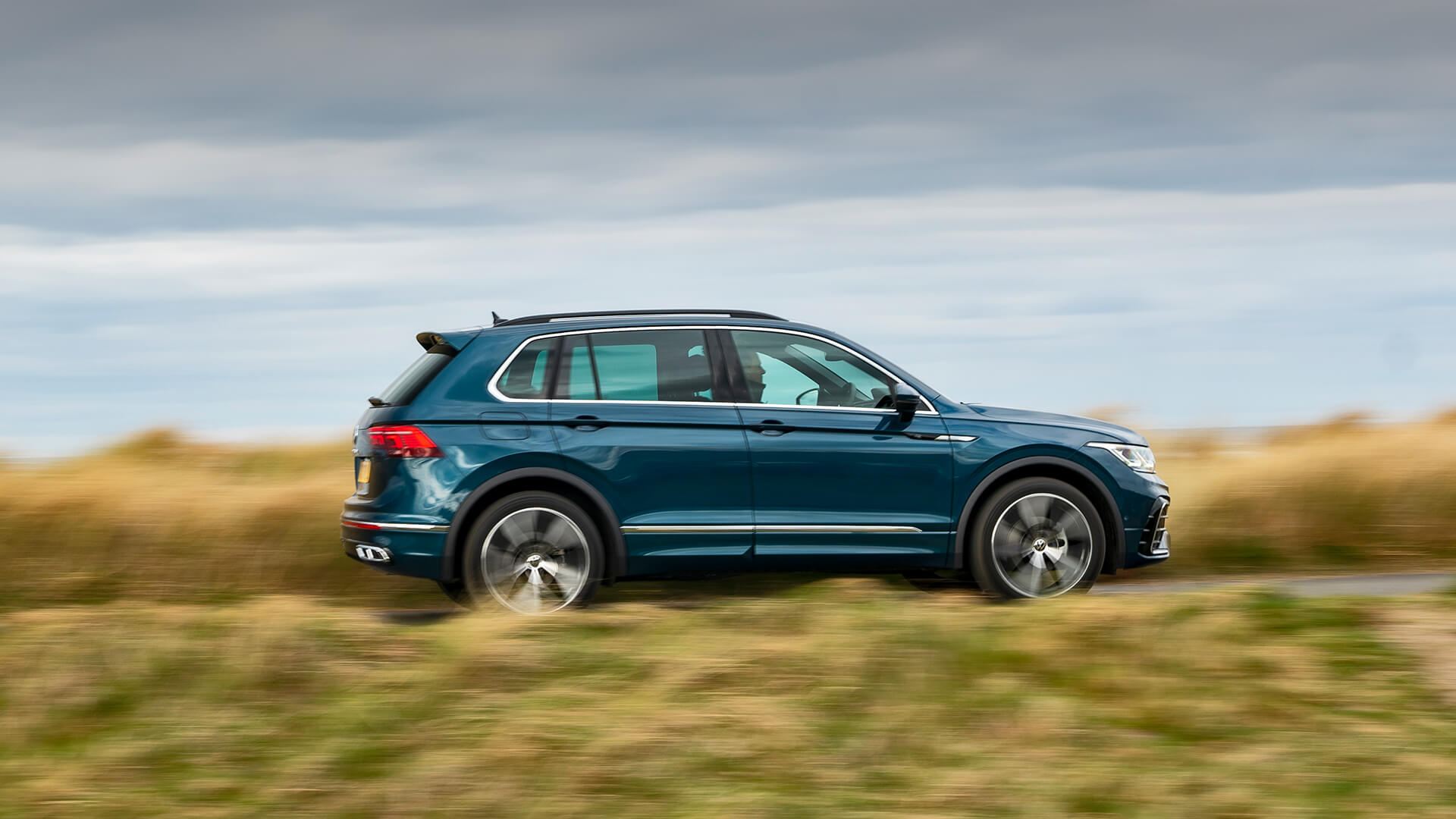 side view of vw tiguan driving on a road