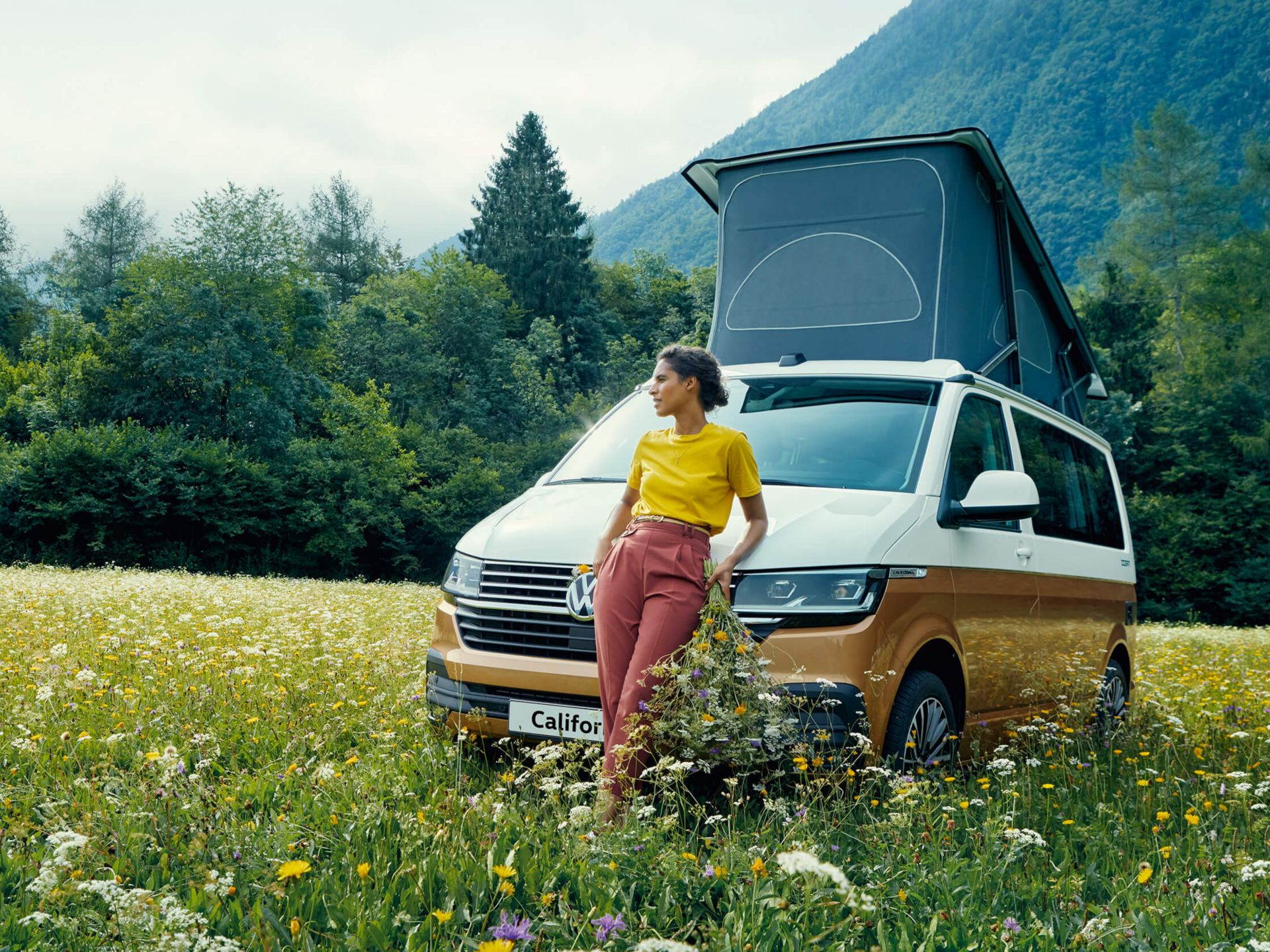 Orange and white Volkswagen California Beach charging