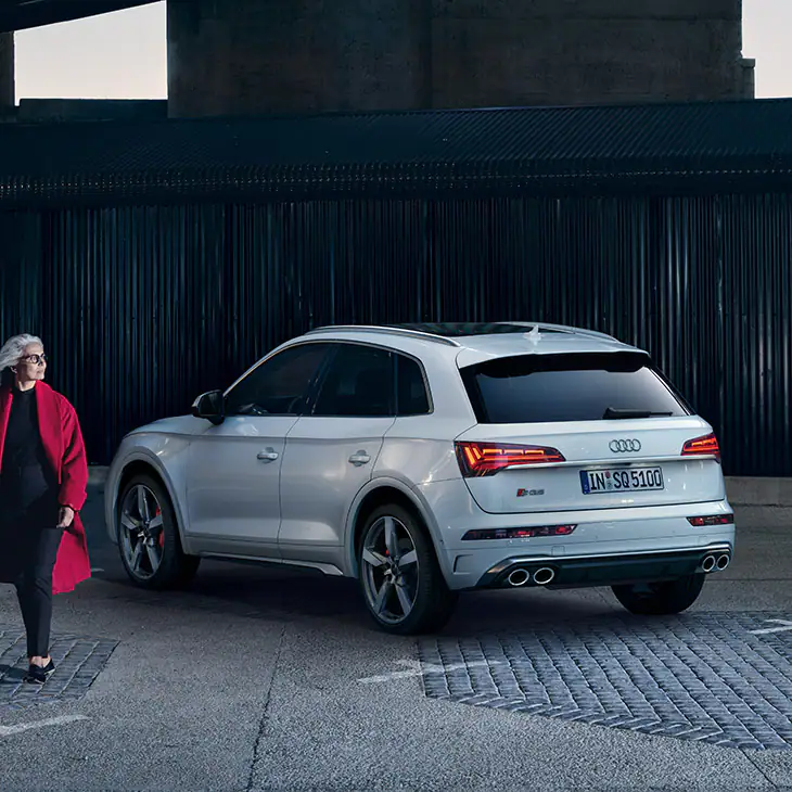 woman walking past white audi sq5