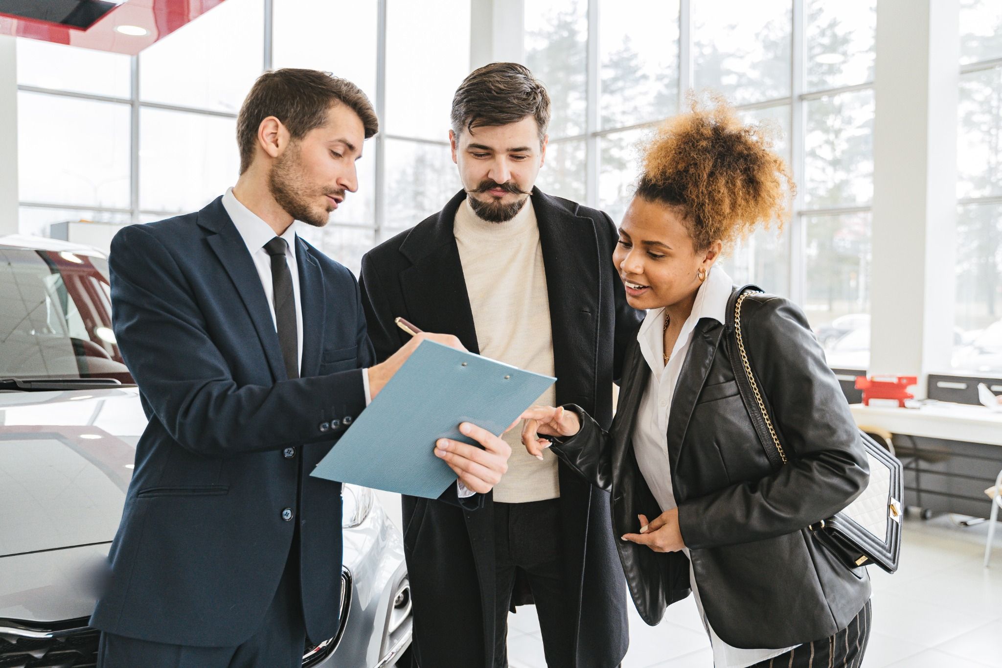 young couple in dealerhsip with sales exec